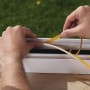Anbringen der weißen Tesamoll Schaumstoff Fensterdichtung (10m x 0,9cm) am Fensterrahmen.