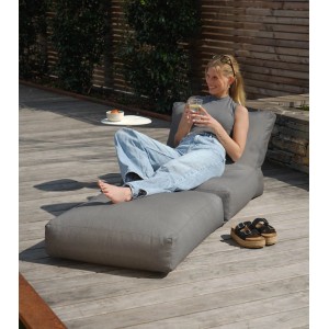 Frau entspannt auf anthrazitfarbenem mokebo Outdoor Sitzsack/Gartenliege Summerdream auf Holzterrasse.