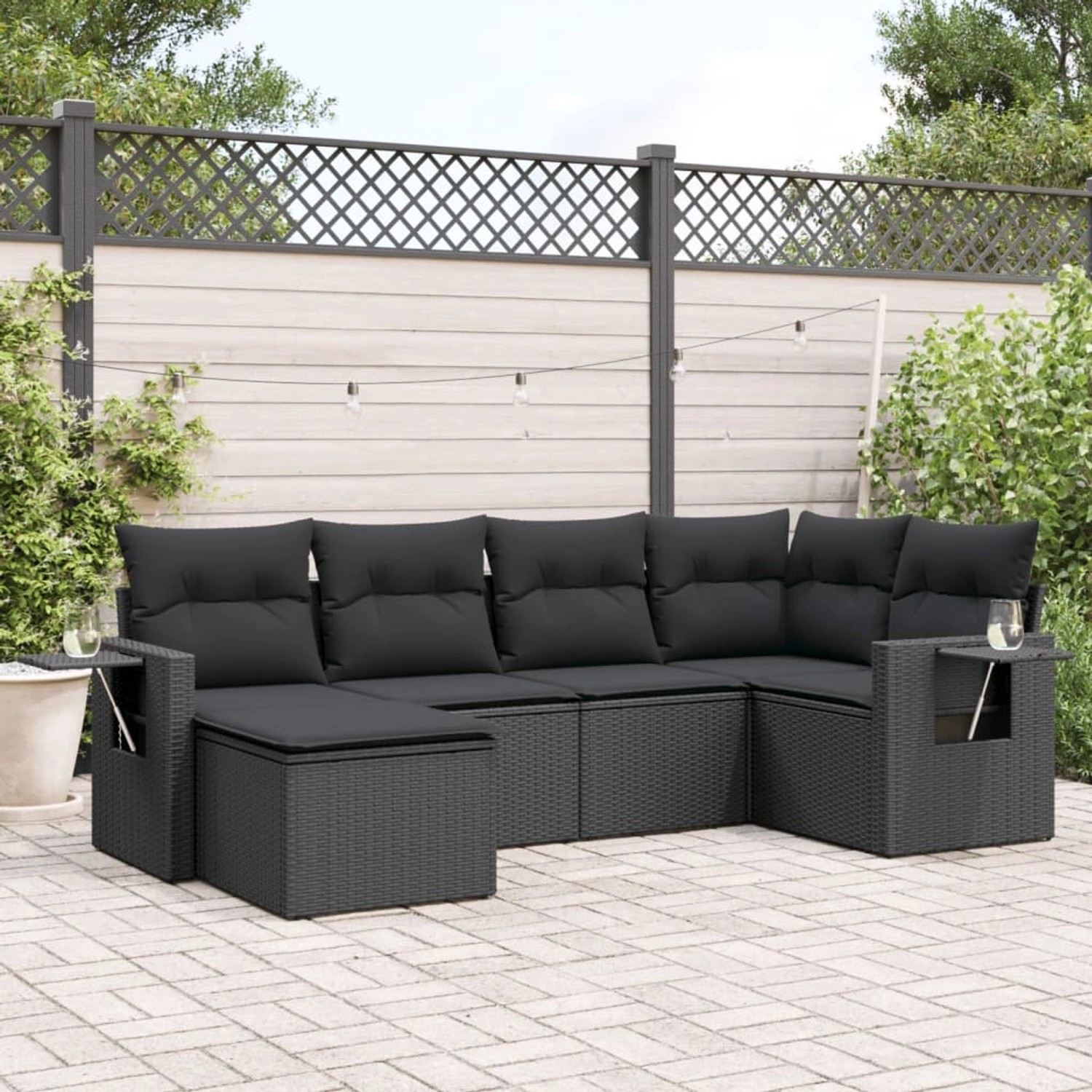 Schwarze 6-tlg. vidaXL Garten-Sofagarnitur aus Poly Rattan mit Kissen im Garten.