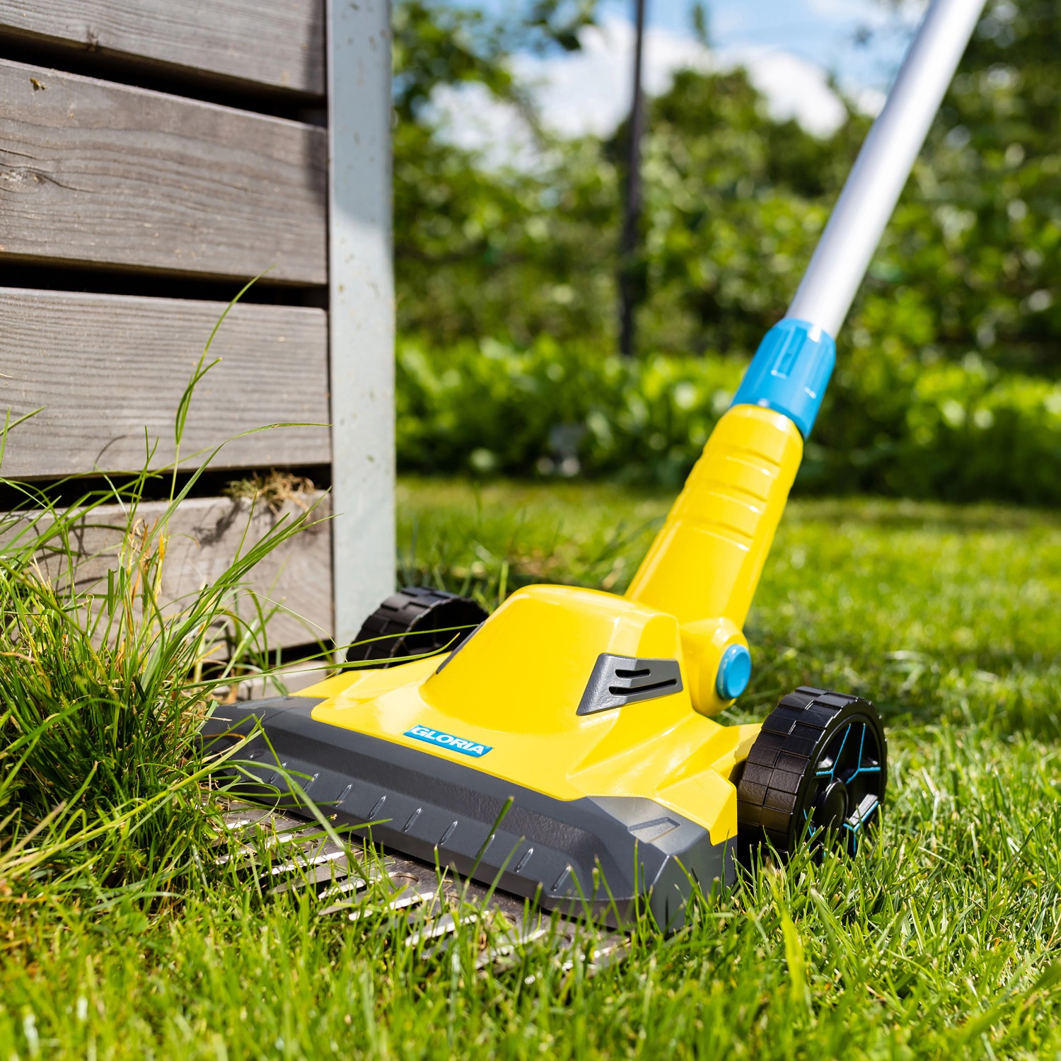 Gelber Gloria Akku-Rasen- und Kantenschneider Finecut 18 V im Einsatz am Rasen.