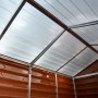 Innenansicht Gerätehaus Skylight Amber: Polycarbonat Dach mit Aluminiumrahmen, braune Wandpaneele.