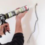 Anwendung von Soudal Express Spachtel Weiß 300ml mit Kartuschenpistole an einer Wand.