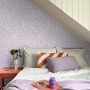 ESTAhome Vliestapete mit Blumenmuster in Violett im Schlafzimmer unter Dachschräge.