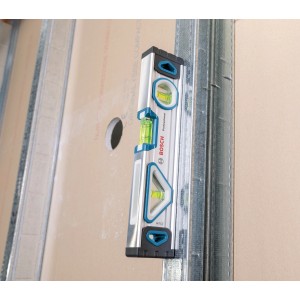 Bosch Professional Wasserwaage (25 cm) haftet magnetisch an Metallwand.