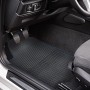 Schwarze OBI Fußmatten mit blauem Rand im Fußraum eines Autos.