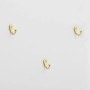 Drei goldene Haken auf weißer Oberfläche, Detail des Garderobenschranks mit Schuhkommode.