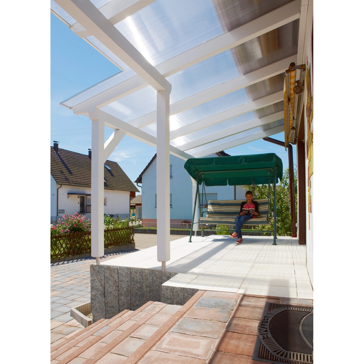 Transparente Gutta Hohlkammerplatte 16 mm als Terrassenüberdachung mit Person auf Schaukel.