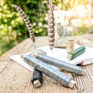 Windhager Gartendraht, 50m Rolle, grün und silber, aufgeschlagenes Buch mit Federn und Dekoration.
