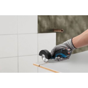 Kompakter Bosch Professional Akku-Winkelschleifer GWS 12 V-76 schneidet Fliese. Blau-schwarzes Schleifgerät in Aktion.