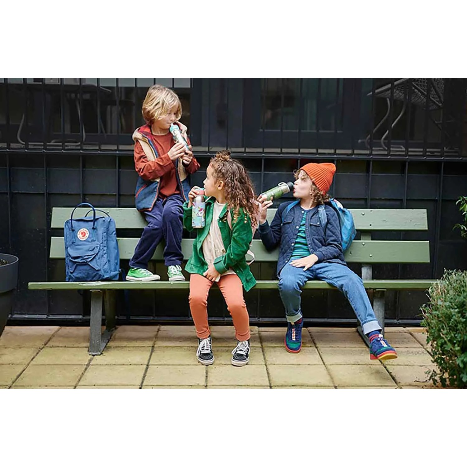 Kinder mit Mepal Campus Lunchset Dino World (Thermosflasche, Brotdose) auf Bank.