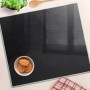 Schwarze Glas Herdabdeckplatte (60x52 cm) als Schneidebrett und Spritzschutz mit Speisen dekoriert.