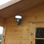 Lutec Solar LED-Strahler Sunshine an Holzwand montiert, mit Solarpanel für Aussenbeleuchtung.