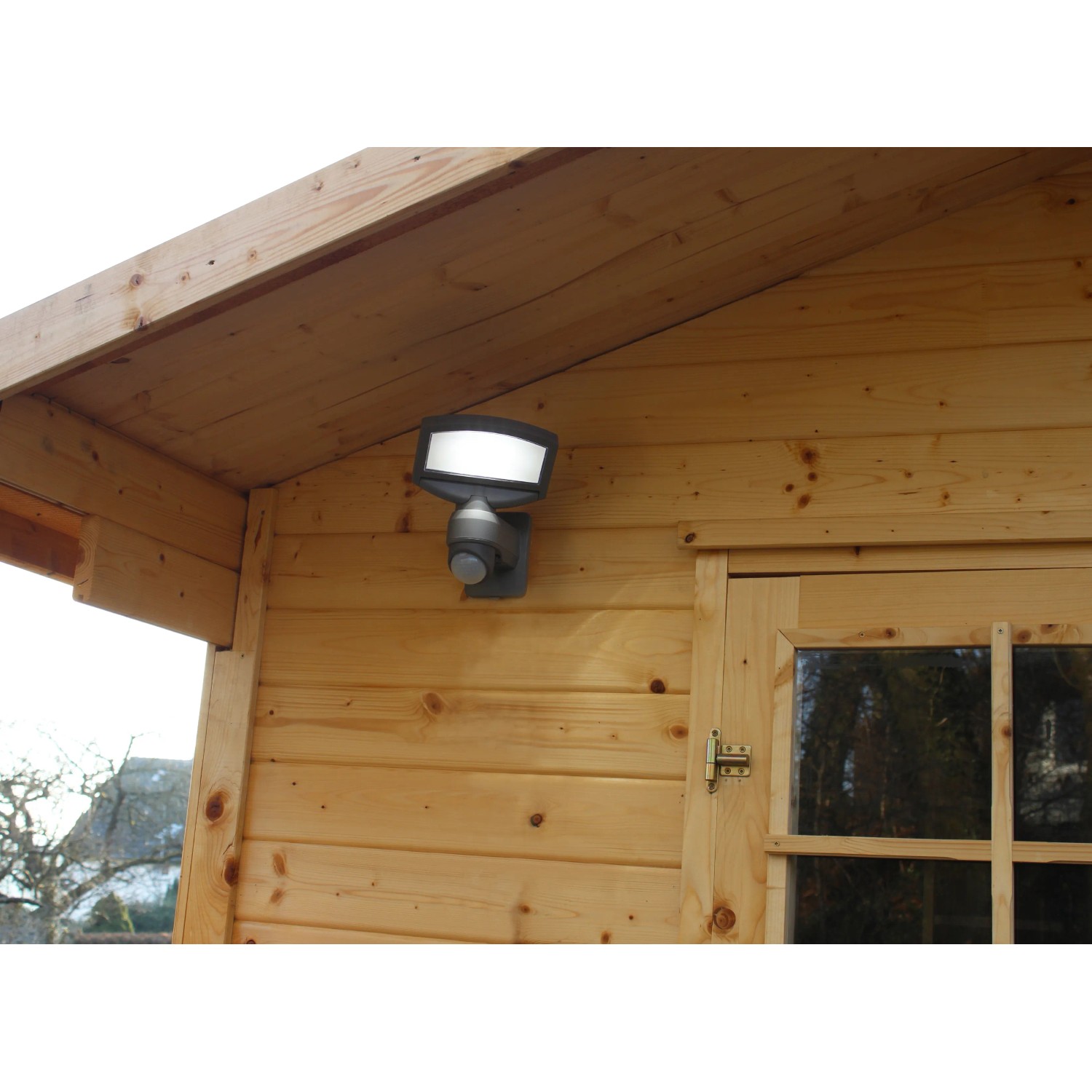 Lutec Solar LED-Strahler Sunshine an Holzwand montiert, mit Solarpanel für Aussenbeleuchtung.