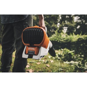 Stihl Akku-Blasgerät BGA 250 Orange-Grau mit Akku, von Person im Garten gehalten. Handlicher Laubbläser.