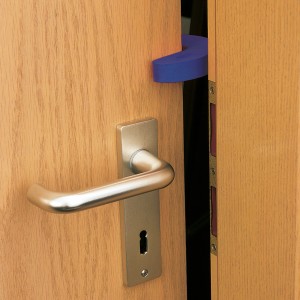 Tür mit blauem Türstopper in C-Form. 2er-Set Türkeile aus Kunststoff.