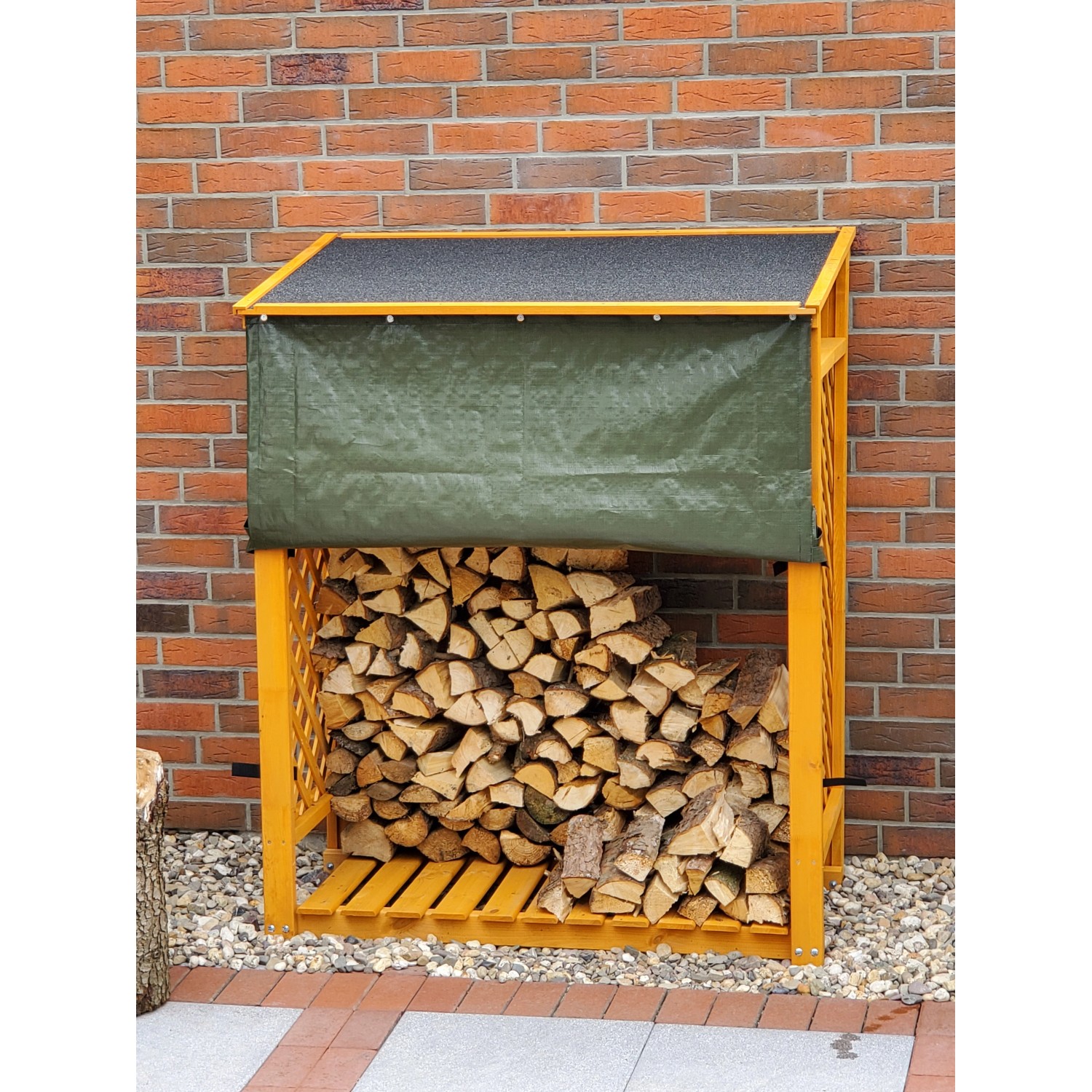 Honigbraunes Kaminholzregal Speyer mit Wetterschutz und Holzfüllung vor einer Backsteinwand.