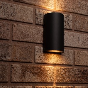 Schwarze, halbrunde 2-flammige LED Außenwandleuchte an Backsteinwand.