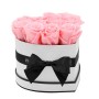 Herzförmige Rosenbox in Weiß mit rosa Rosen und schwarzer Schleife.