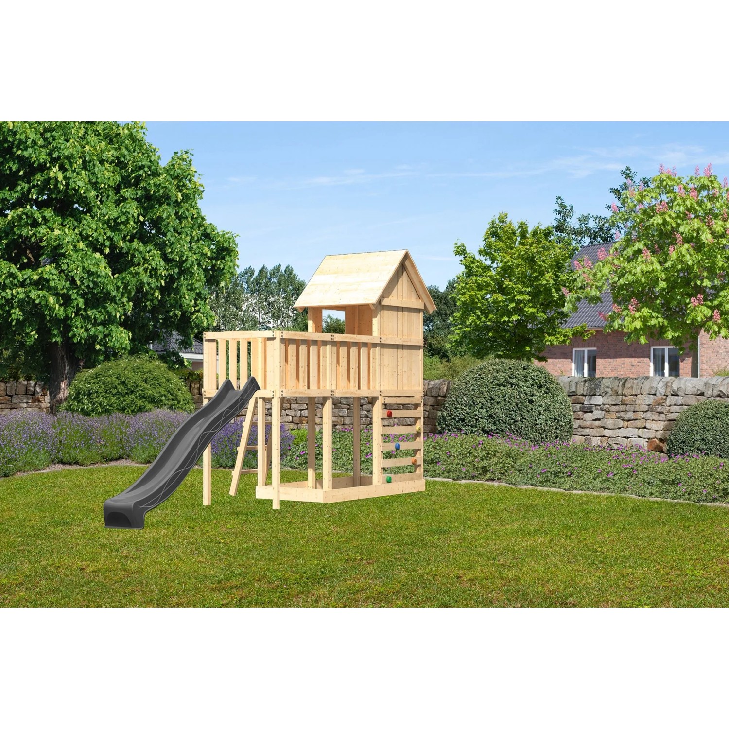 Karibu Spielhaus Frieda mit Rutsche, Anbauplattform und Kletterwand im Garten.