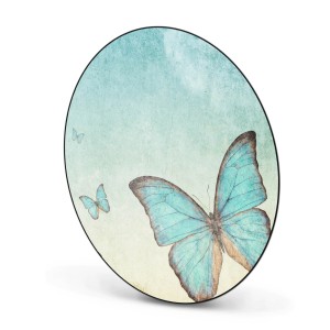 Runde, schwarze Magnettafel mit blauem Schmetterlingsmotiv als Wanddekoration.