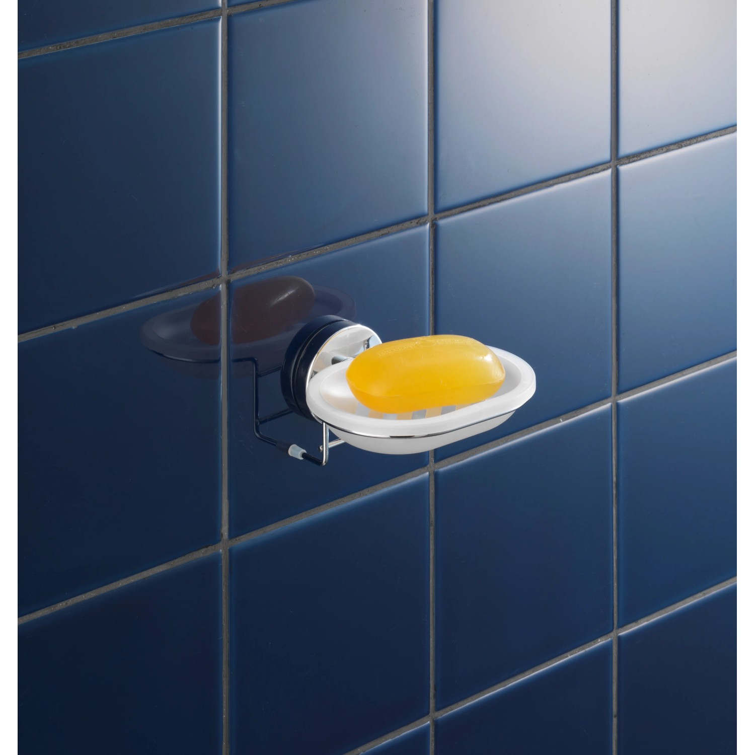 Wenko Vacuum-Loc Seifenablage Milazzo, Chrom/Weiß mit gelber Seife an blauer Wand.