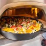 Buschbeck Pizzaofen X1 mit Pizza im Ofen. Gas- und Holzbefeuerung für knusprige Pizza.