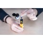 Hände füllen gelben Pica Ink Tieflochmarker mit roter Tinte per Pipette nach. Präzises Messwerkzeug für Bohrlöcher.