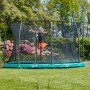 Grünes Salta Comfort Edition Bodentrampolin (ø 427 cm) mit Kind im Garten.