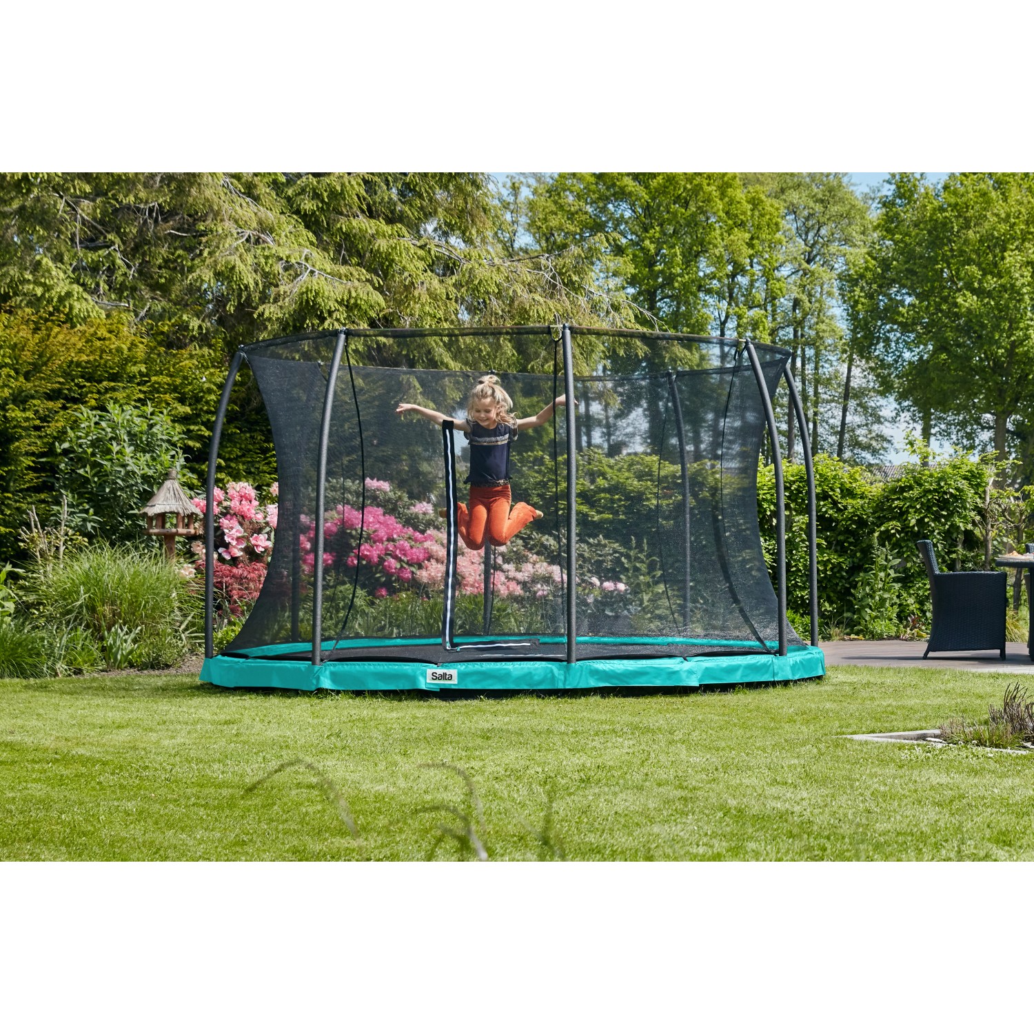 Grünes Salta Comfort Edition Bodentrampolin (ø 427 cm) mit Kind im Garten.