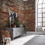 Komar Vliesfototapete Bricklane mit Backsteinmauer-Motiv im Wohnraum.