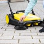Gelbe Kärcher Kehrmaschine S6 Twin mit zwei Seitenbesen im Einsatz.