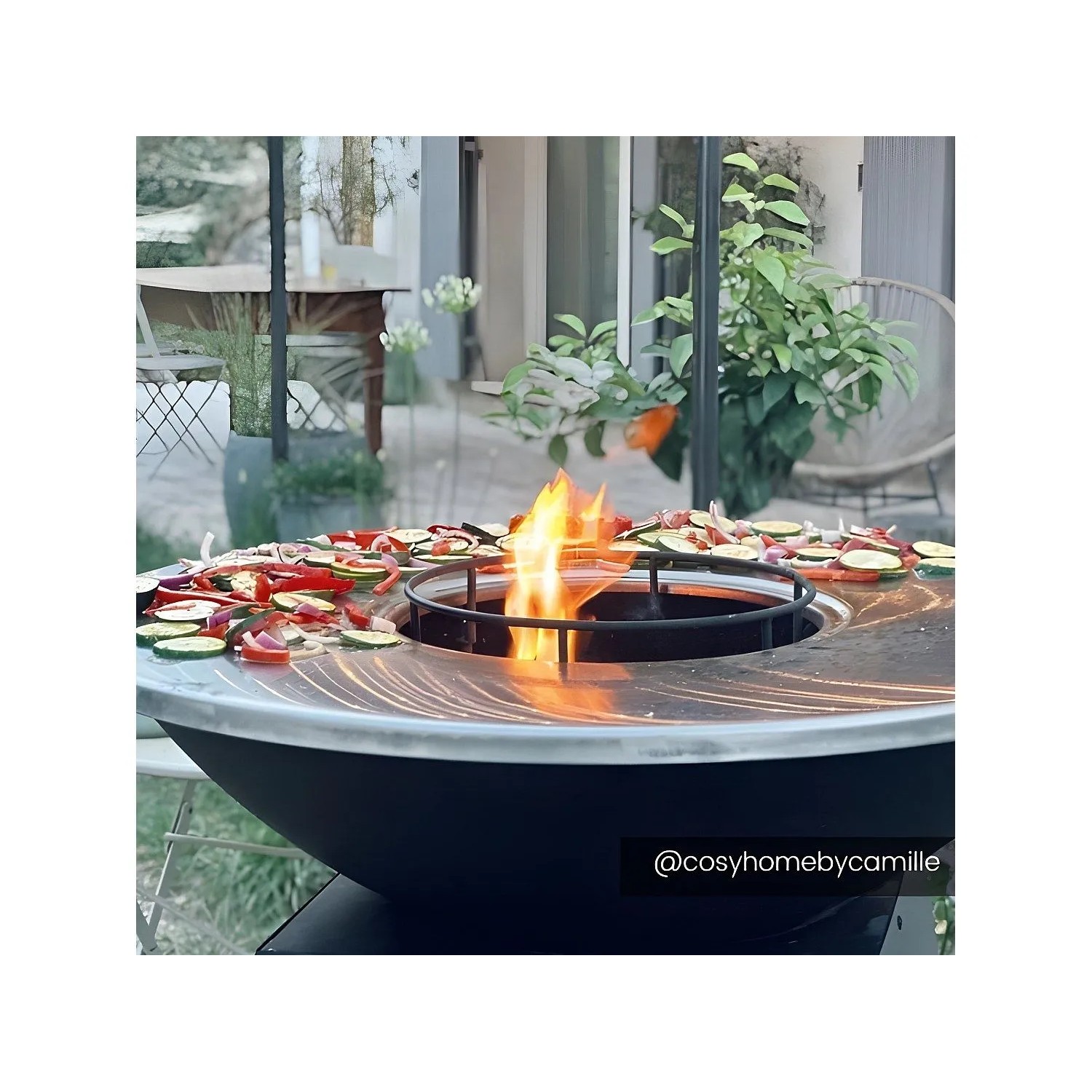 Schwarzer Vente-unique Grill Corvera 81 cm mit Plancha-Ring und Feuerstelle, Gemüse wird gegrillt.