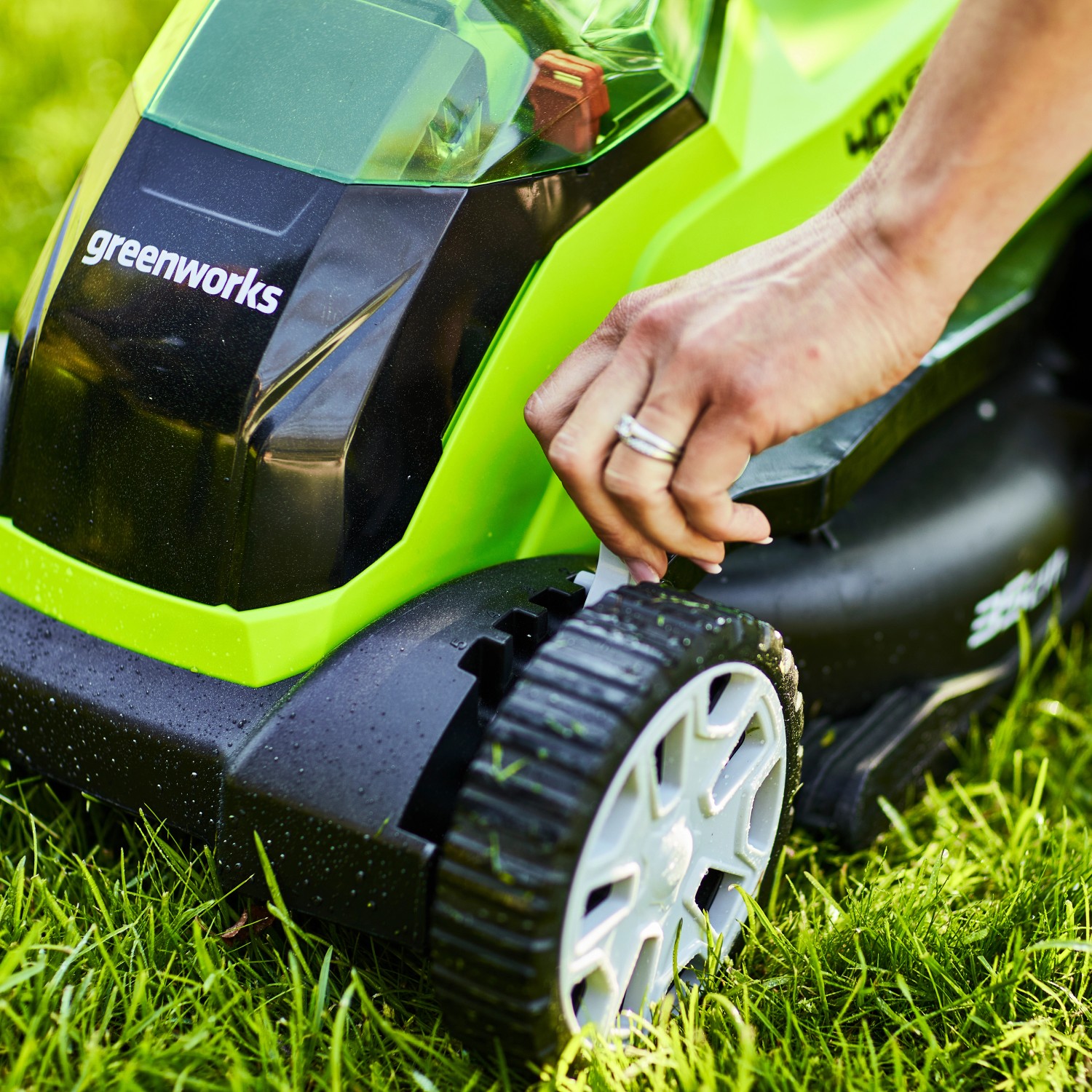 Greenworks Akku-Rasenmäher G40LM35K2: Frau verstellt Schnitthöhe am Rasenmäher.