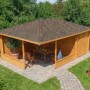 Imprägnierte 5-Eck Gartenlaube Maik-40 Natur mit Anbau und Spitzdach im Garten.