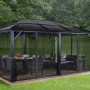 Anthrazitfarbener Sojag Pavillon Meridien 12x16 mit Moskitonetz und Möbeln im Garten.