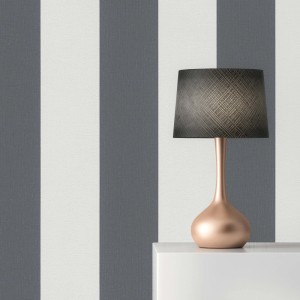 Graue und weiße Vliestapete mit Streifenmuster, dekoriert mit einer Lampe auf einem Regal. Ideal für moderne Wandgestaltung.