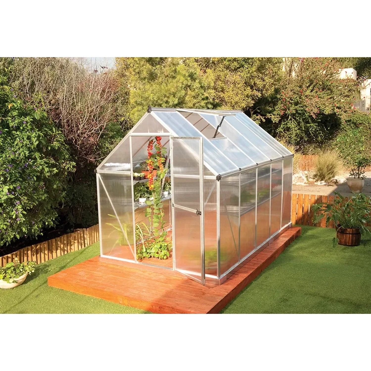 CANOPIA Gewächshaus Mythos Silber 5,7 m² mit Fundamentrahmen, auf Holzterrasse im Garten.
