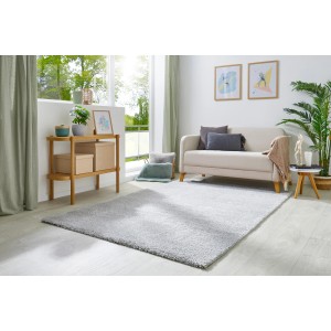 Grauer Andiamo Teppich Chia, 60x110 cm, in modernem Wohnraum mit Sofa und Dekoration.