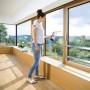 Frau reinigt Fenster mit Kärcher Akku-Fensterreiniger WV 6 Plus P (weiß-schwarz).