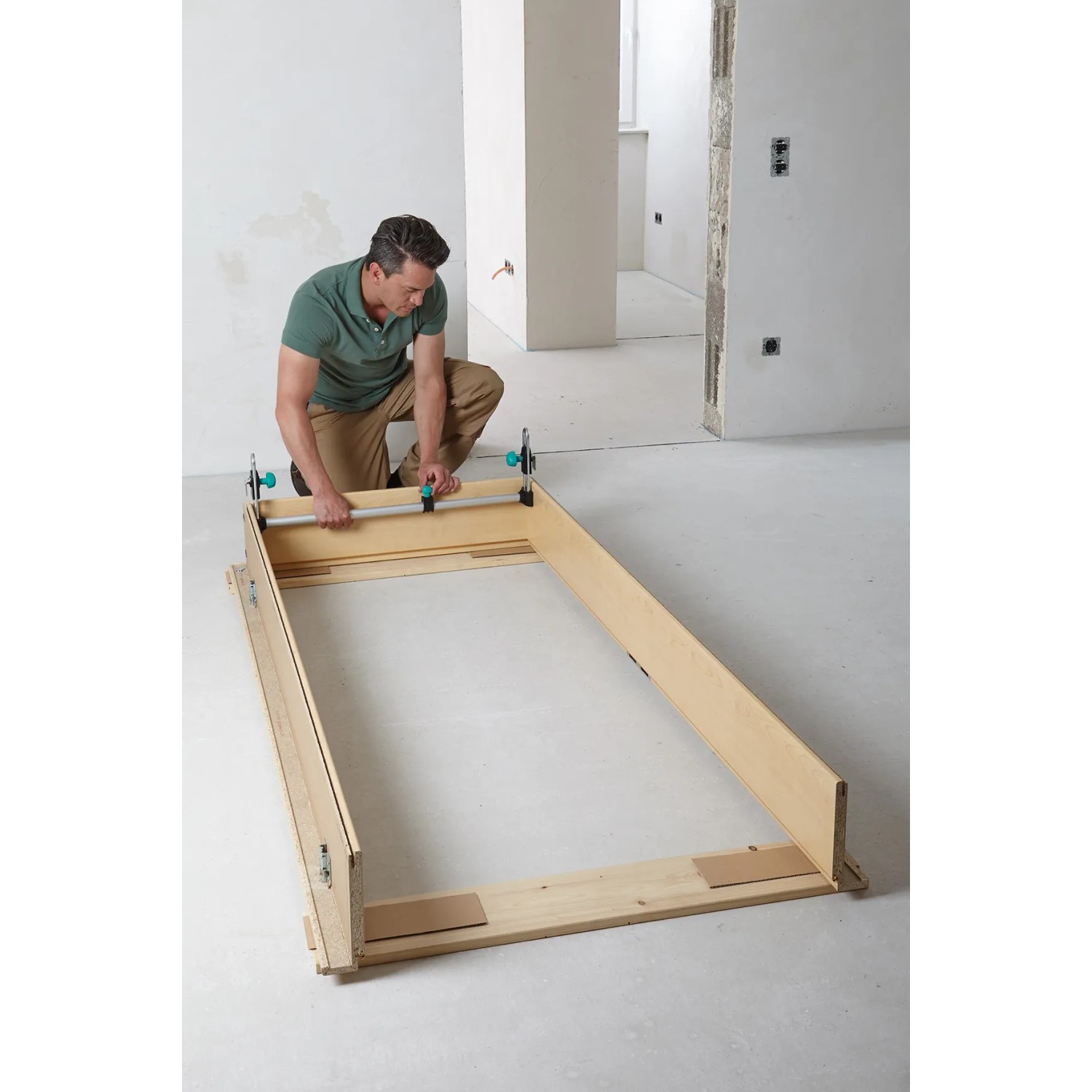 Mann montiert Türfutter mit Wolfcraft Türfutterstrebe Easy. Spannwerkzeug zur Montage von Türrahmen.