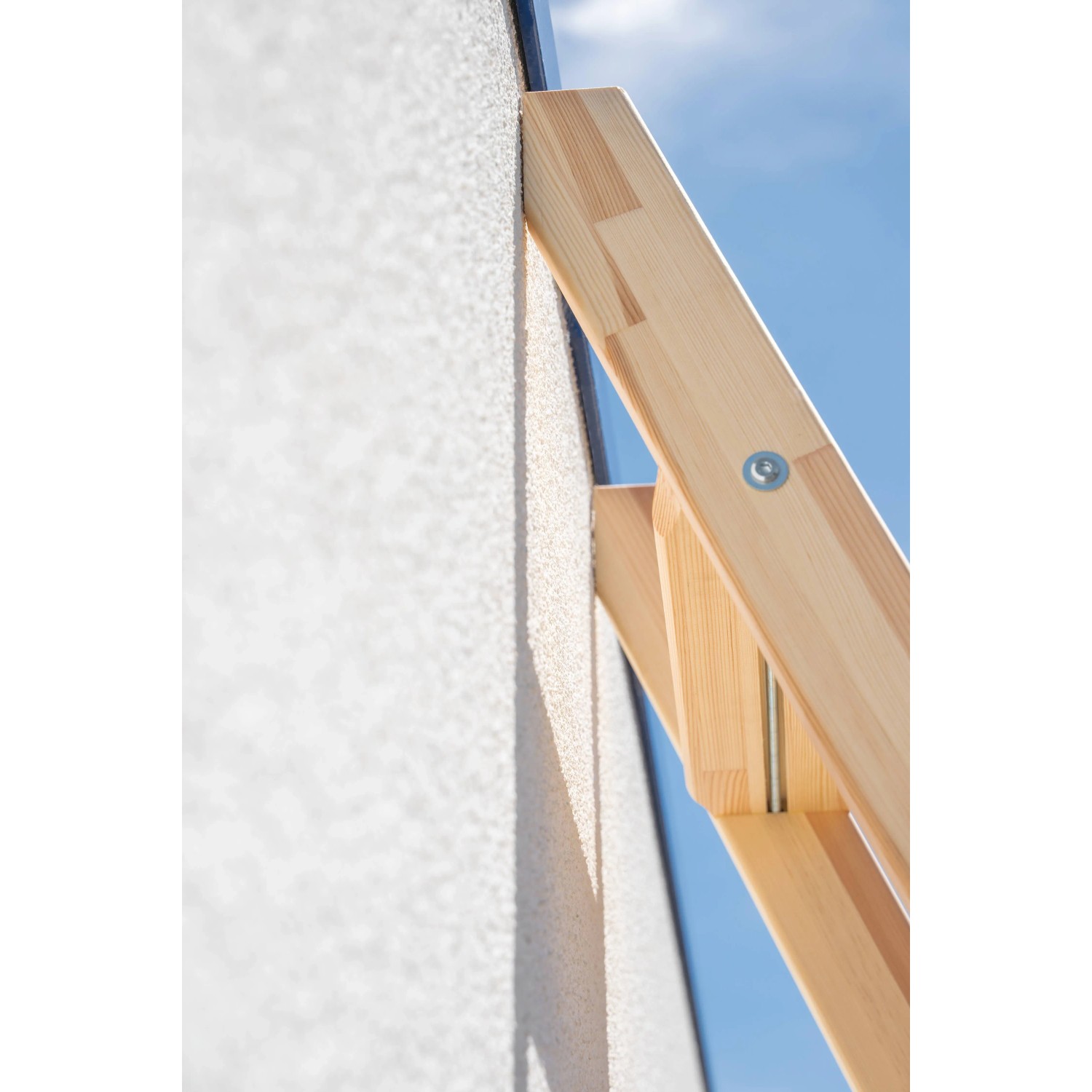 Detailaufnahme: Holz-Anlegeleiter mit 6 Stufen an einer Wand. Leiter aus Kiefernholz.