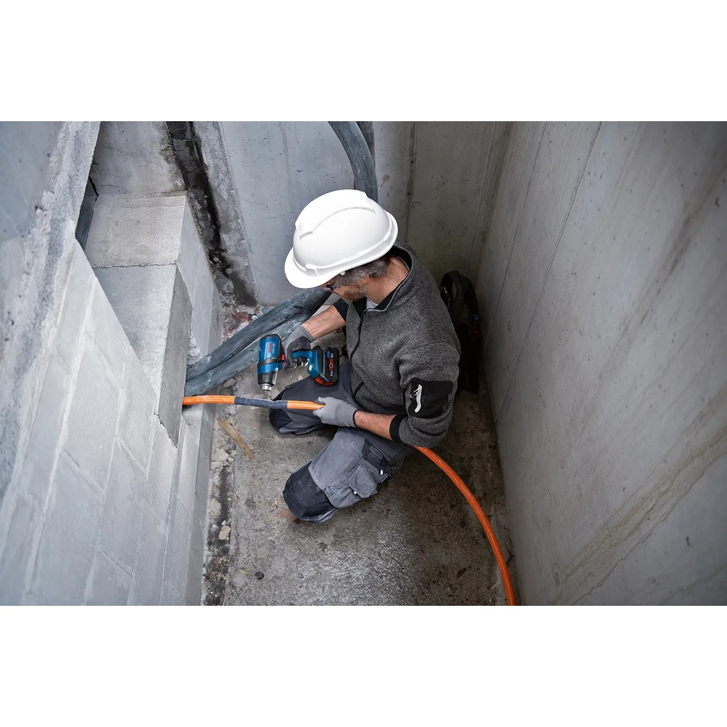 Handwerker nutzt Bosch Professional Akku-Heißluftgebläse GHG 18 V-50 zum Schrumpfen eines Kabels.