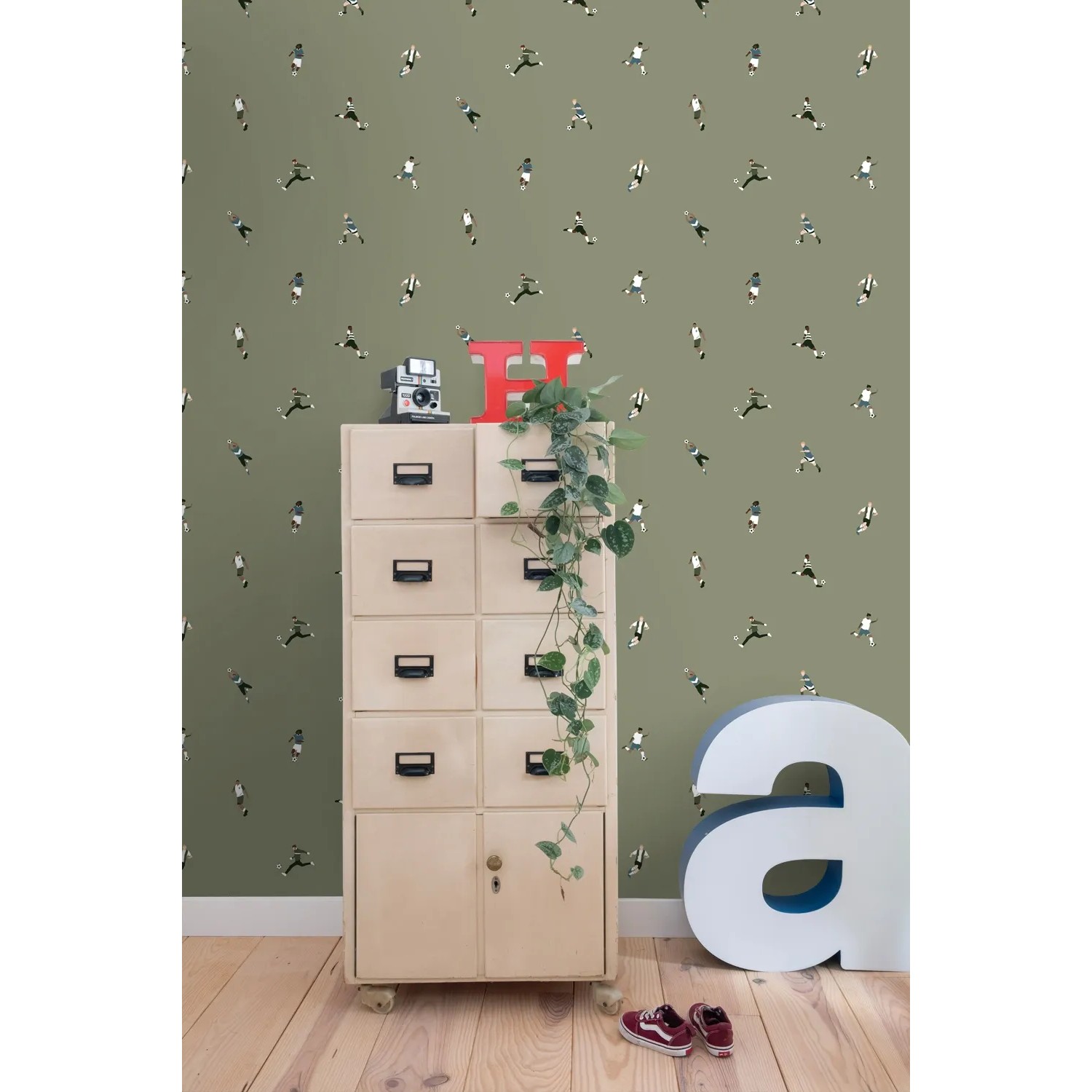 Olivgrüne ESTAhome Vliestapete mit kleinen Fußballspielern an der Wand, ideal für Kinderzimmer.