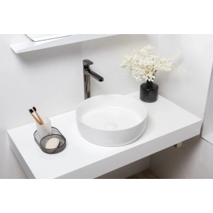 Runde, weiße matte Waschschale mit Ablaufgarnitur auf Waschtischplatte im modernen Bad. Ideal für Gäste-WC.