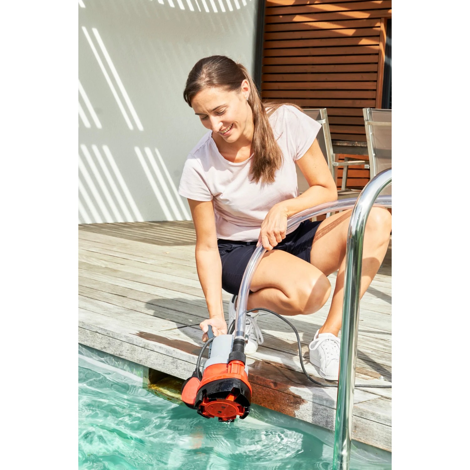 Frau nutzt Al-Ko Tauchpumpe Drain 9500 Easy zum Abpumpen von Poolwasser.