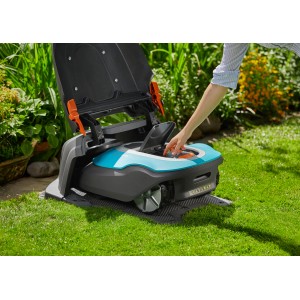 Gardena Garage für Sileno Mähroboter mit geöffnetem Deckel im Garten.