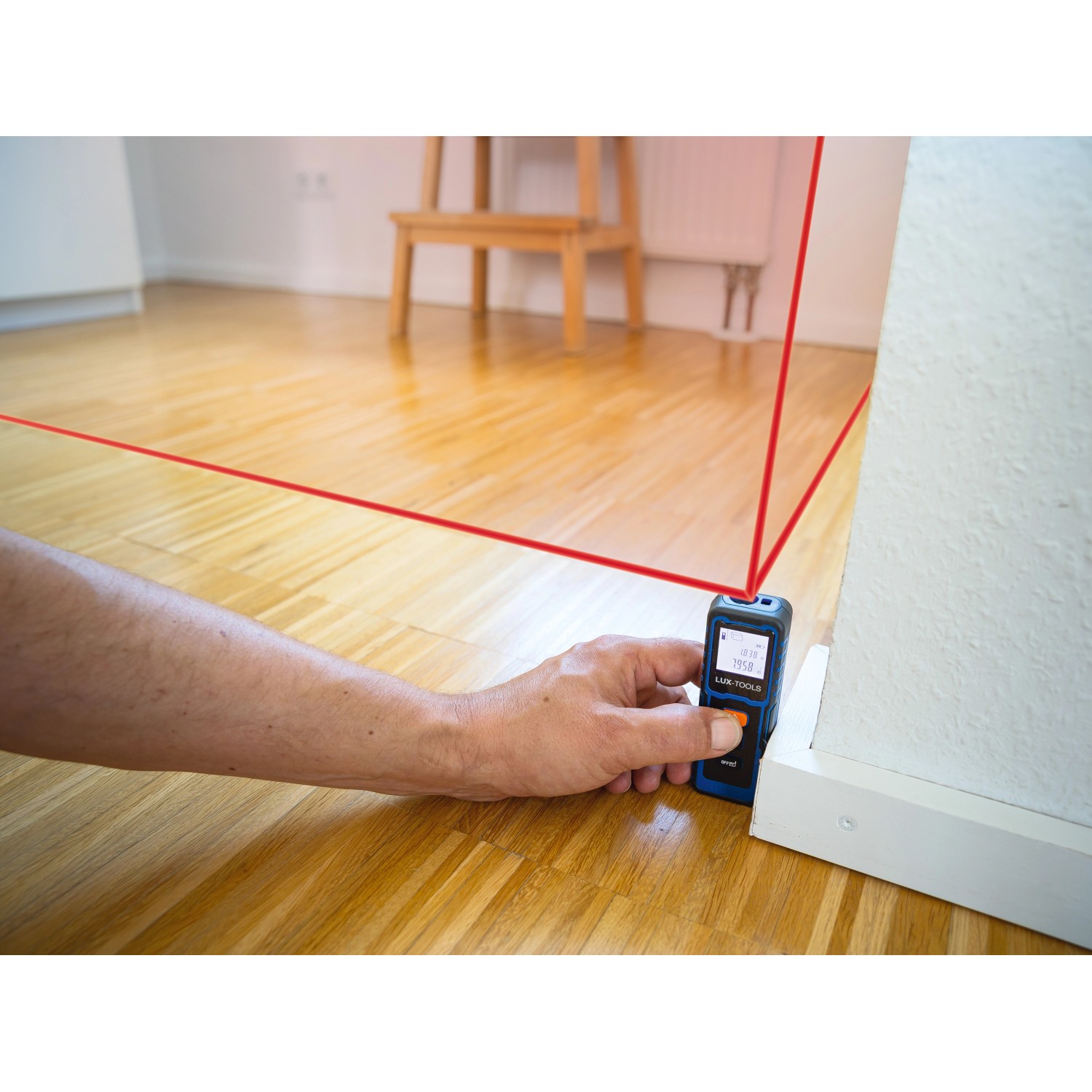 Hand misst Raum mit LUX-TOOLS Laser-Entfernungsmesser. Präzises Messwerkzeug für Heimwerker.
