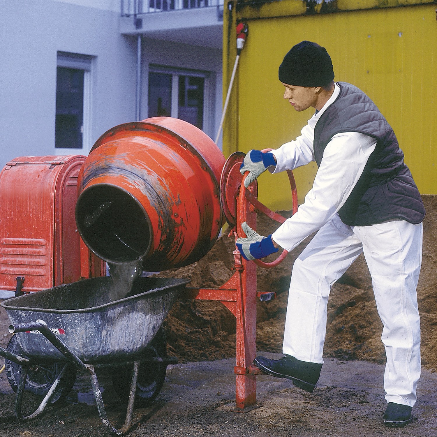 Mann mit LUX Winterarbeitshandschuhen Gr. 10 bedient Betonmischer.