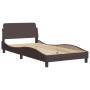 Dunkelbraunes Stoffbett mit Matratze, 100x200 cm, Lattenrost und wellenförmigem Design.