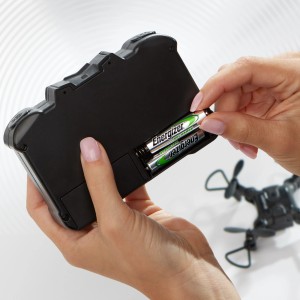 Hand legt Energizer AA Akku in ein Gerät. Power Plus Mignon Akkus, 4er Pack.